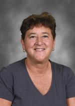Dena Koser-Hanna has short hair, she is wearing a dark shirt