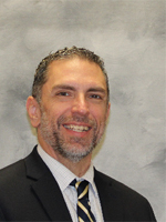 Jason Kushak is wearing a business suit and tie.